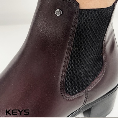 Botim de pele castanho escuro com elástico preto e tacão baixo