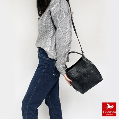 Mulher com camisola cinzenta e jeans azul, mala preta Cavalinho Penafiel