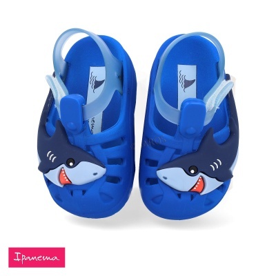 Sandálias azuis para crianças com desenho de tubarão e tira ajustável.