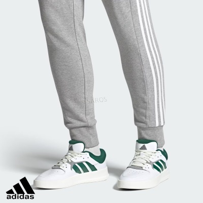 Ténis Adidas branco com riscas verdes e calças de treino cinzentas com três riscas brancas