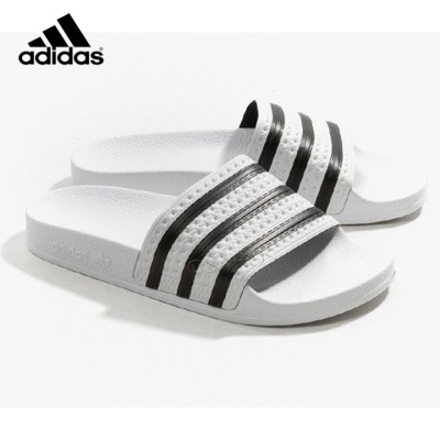 Chinelos Adidas brancos com riscas pretas e logo em relevo