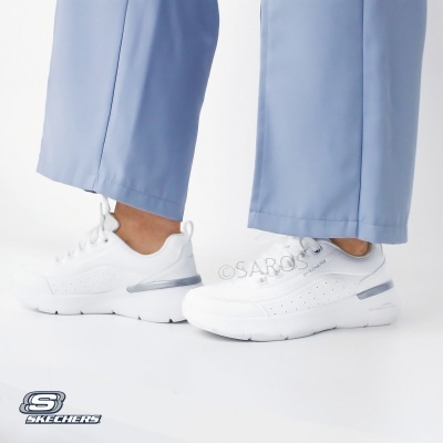 Ténis Skechers brancos com detalhes cinzentos e sola grossa usados com calças azuis claras