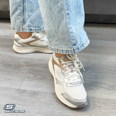 Ténis brancos Skechers com detalhes prateados e bege usados com calças de ganga claras
