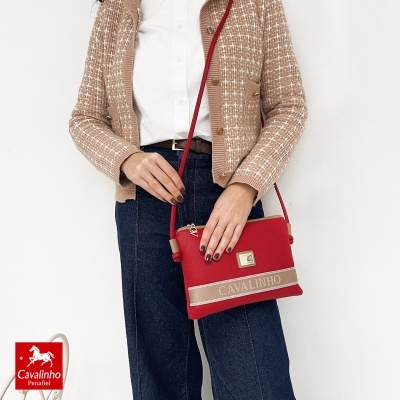 Mala vermelha com faixa bege e bordo branco com o texto CAVALINHO
