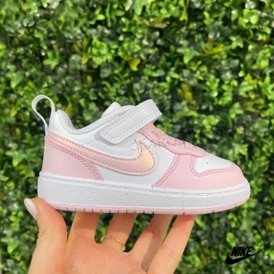 Ténis infantis Nike branco e rosa com símbolo Swoosh iridescente e fundo verde