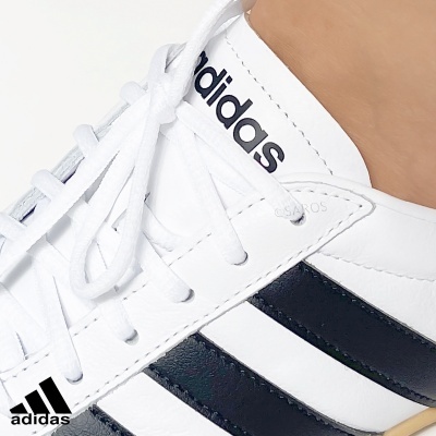 Ténis Adidas brancos com riscas pretas e logo na língua