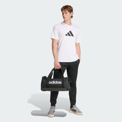 Homem com t-shirt branca Adidas, calças pretas e mochila preta com logo Adidas