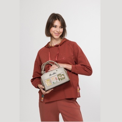 Mala de mão cinza claro com decoração colorida e alças metálicas retorcidas.