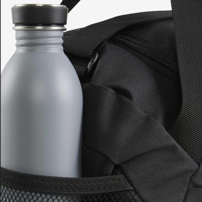 Garrafa cinza metálica numa mochila preta com alças largas