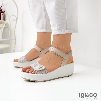 Sandálias de cunha bege e cinza com sola branca e calças brancas