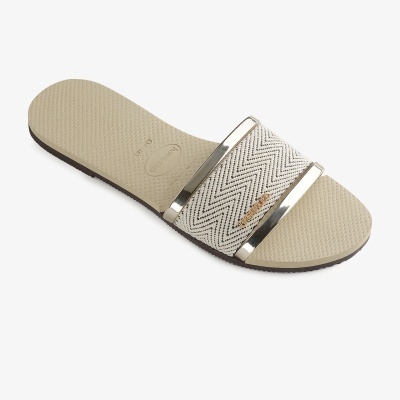 Chinelo slide Havaianas bege com tira branca com padrão ziguezague.