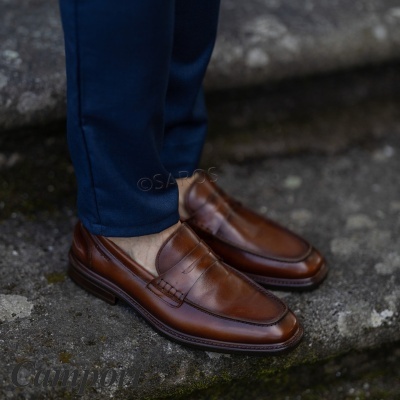 Sapatos masculinos tipo mocassim em pele castanha com costuras e sola castanha escura