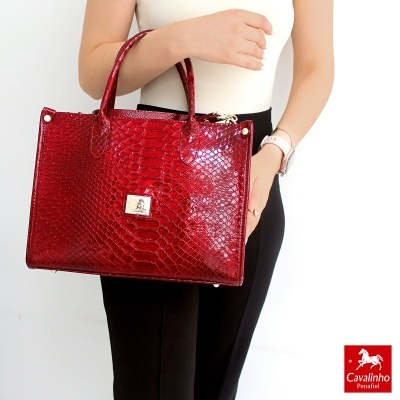 Mala de mão vermelha com padrão de pele de réptil e detalhes metálicos
