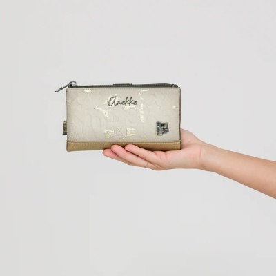 Carteira bege e castanha com padrão texturizado e texto Anekke, segurada por uma mão