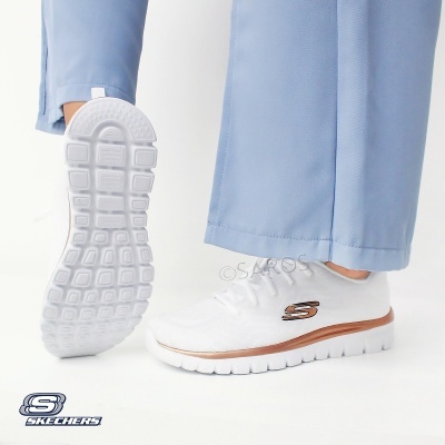 Ténis brancos Skechers com sola branca e detalhes dourados usam calças azuis claras