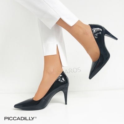 Sapatos de salto alto em verniz preto com bico fino e calças brancas