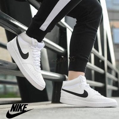 Sapatilhas Nike Air Force 1 Mid brancas com Swoosh preto num ambiente urbano