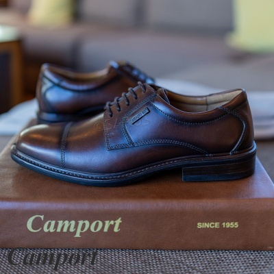 Sapatos de pele castanha com atacadores sobre caixa Camport