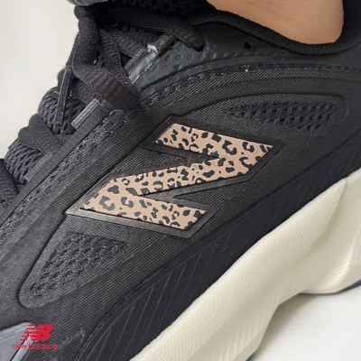 Tênis desportivo preto com logo New Balance animal print e sola branca