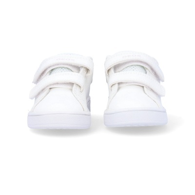 Tênis infantis brancos com fecho de velcro duplo sobre fundo branco