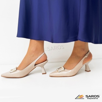Sapatos de salto médio bege com fivela dourada e vestido azul escuro