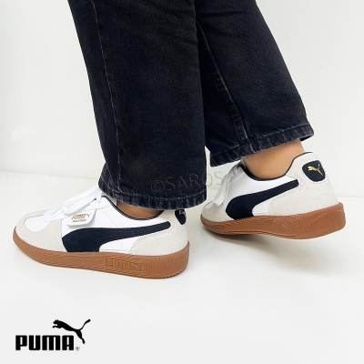 Ténis brancos e pretos PUMA com sola castanha usados com calças pretas