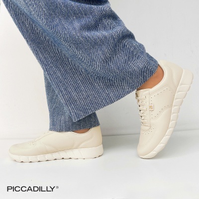 Ténis creme com sola branca usados com calças de ganga azul claro