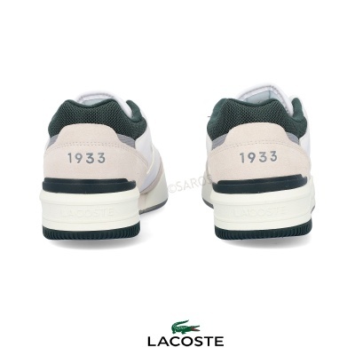 Par de ténis Lacoste brancos e verdes com número 1933 na parte traseira e sola de borracha verde e branca.