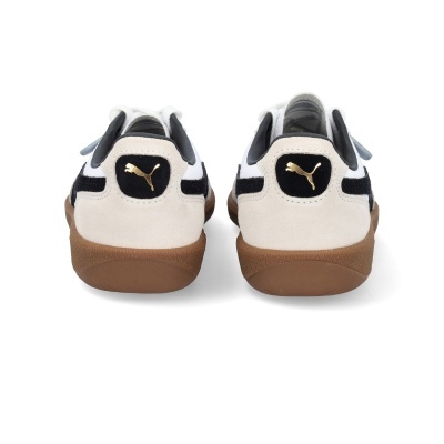 Sapatilhas Puma brancas e pretas vista de trás com sola castanha