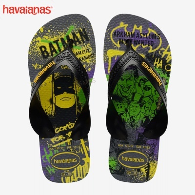 Chinelos Havaianas com estampas coloridas de Batman e Joker, tiras pretas com logo amarelo.