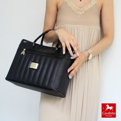 Mala preta de couro com alças, textura matelassê e placa dourada em detalhe