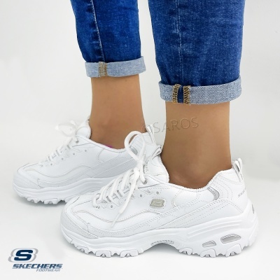 Ténis brancos Skechers com sola espessa usados com jeans dobrados