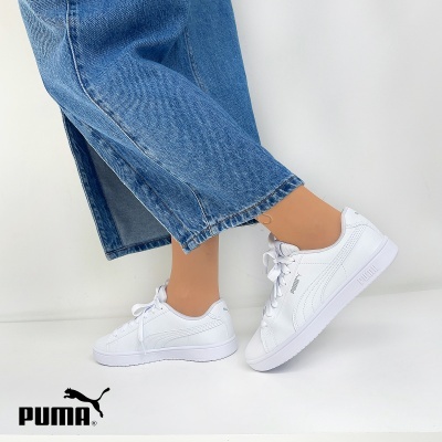 Ténis brancos PUMA com calças de ganga azuis