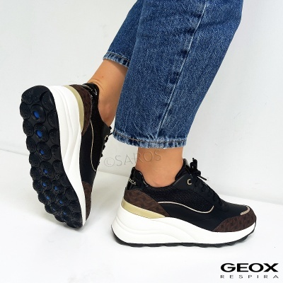 Tênis Geox Respira pretos com detalhes castanhos e bege, solas brancas grossas, calças de ganga azuis.