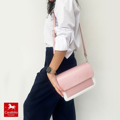 Mala rosa claro com detalhe branco e relevo de cavalo, alça ajustável, em fundo branco.