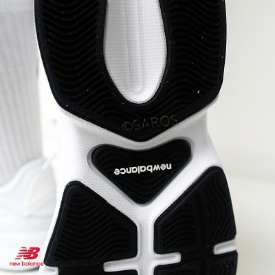 Sola de sapato desportivo New Balance com padrões pretos e texto