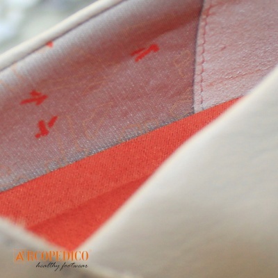 Sapato branco com interior vermelho e cinza com setas vermelhas e logo Aeropedico