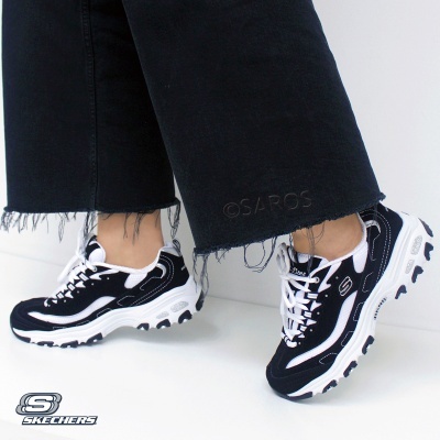 Ténis Skechers preto e branco com sola grossa e calças pretas com bainha desfiada