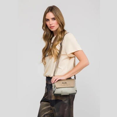 Mulher com mala de ombro bege e roupa clara