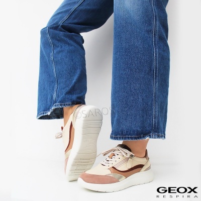 Sapatilhas Geox Respira creme, bege e castanho com solado branco em pessoa com calças de ganga azuis
