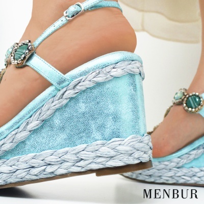 Sapatos de cunha azul metálico com detalhes brancos e ornamento verde