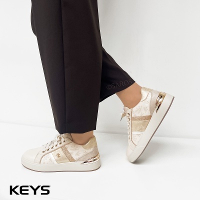 Ténis brancos com detalhes dourados e padrão discreto