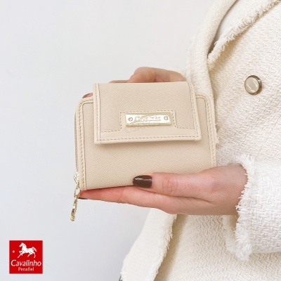 Carteira bege Cavalinho segura por mão de mulher