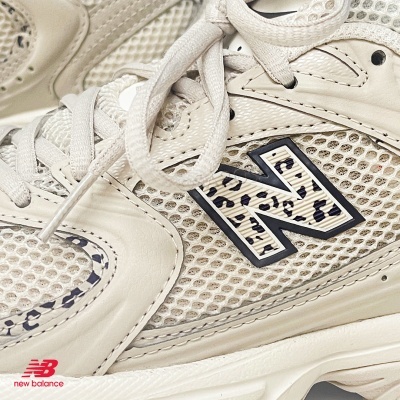Ténis New Balance creme com rede e padrão animal print no logo