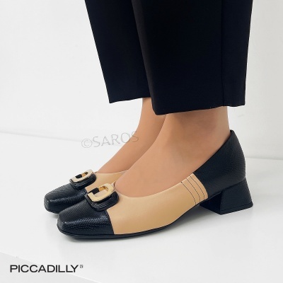 Sapatos de senhora bicolores com salto baixo e fivela dourada.