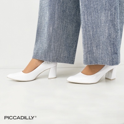 Sapatos de salto alto brancos em verniz com calças largas azul claro