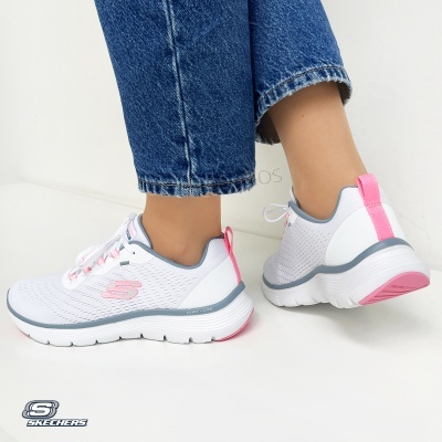 Sapatilhas Skechers brancas com detalhes rosa e cinza usadas com jeans azuis