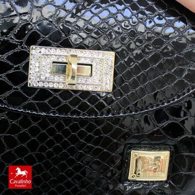 Bolsa preta textura pele de réptil com fecho dourado e cristais