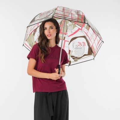 Mulher com guarda-chuva transparente com padrões vermelhos e bege e t-shirt bordeaux