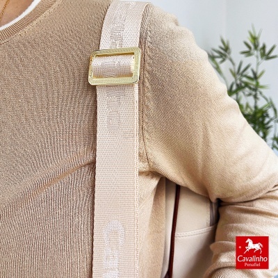 Alça larga bege com peça metálica dourada com nome Cavalinho